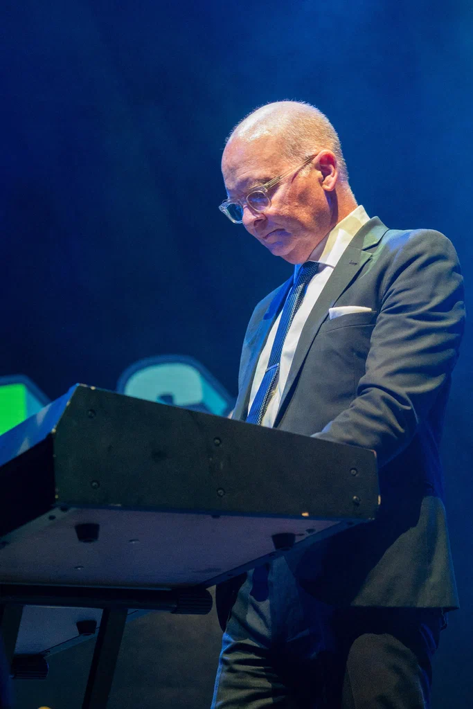A man in a suit and glasses plays a keyboard on stage at JoCo Cruise 2025.