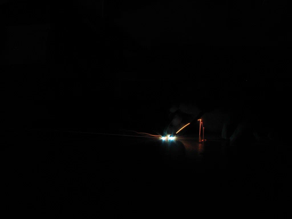 Bright sparks and arcs of electricity are visible emitting from high-voltage equipment against a dark background.
