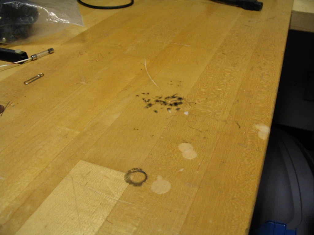 A high-voltage device is sparking, with visible electrical discharge, on a workbench surface.