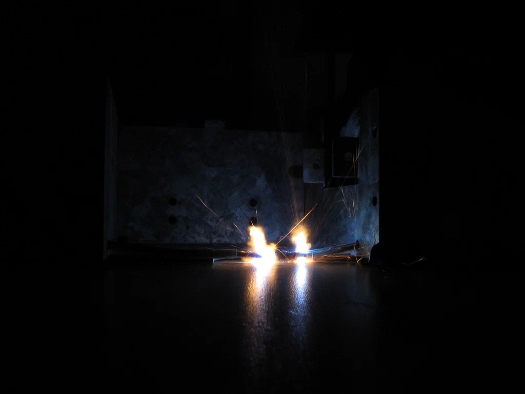 Sparks flying from a high-voltage electrical device during operation or testing.