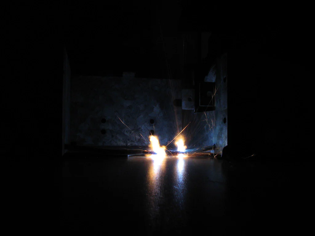 Sparks flying from a high-voltage electrical device during operation or testing.